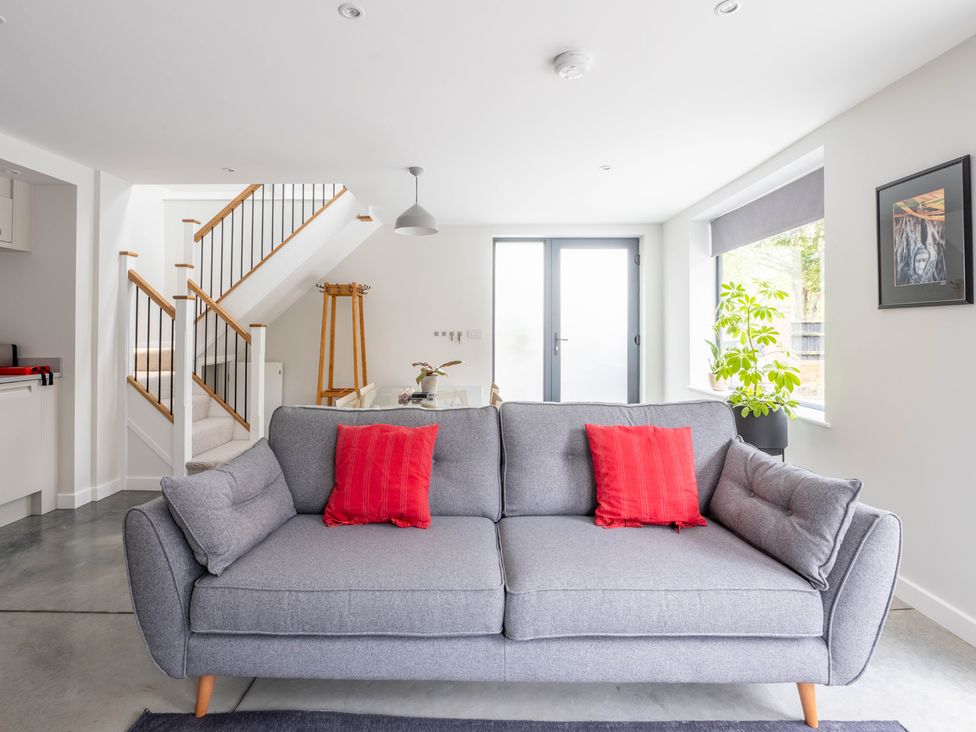 A living room with a sofa and staircase at Blackwood in Hornsea