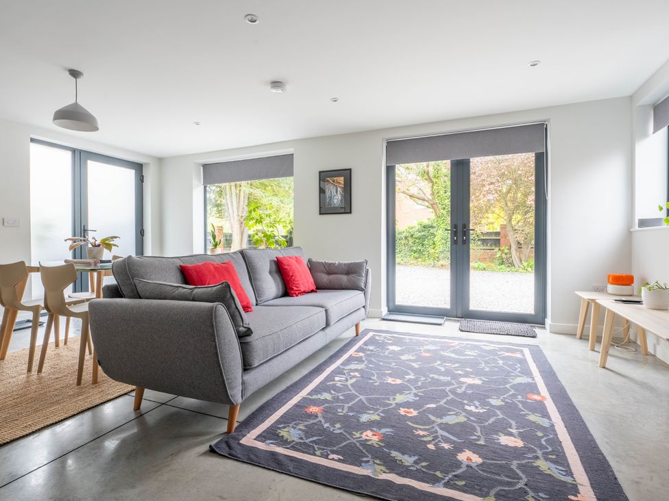 A living room with a sofa, dining table, and sliding doors at Blackwood in Hornsea