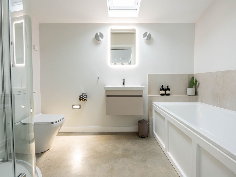 A bathroom with bath, sink, toilet, and shower at Blackwood in Hornsea