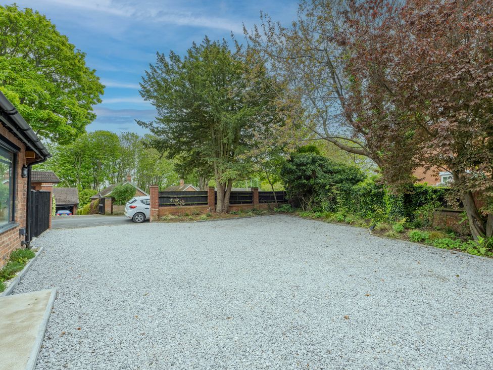 A gravel parking area with a car and trees at Blackwood Hornsea