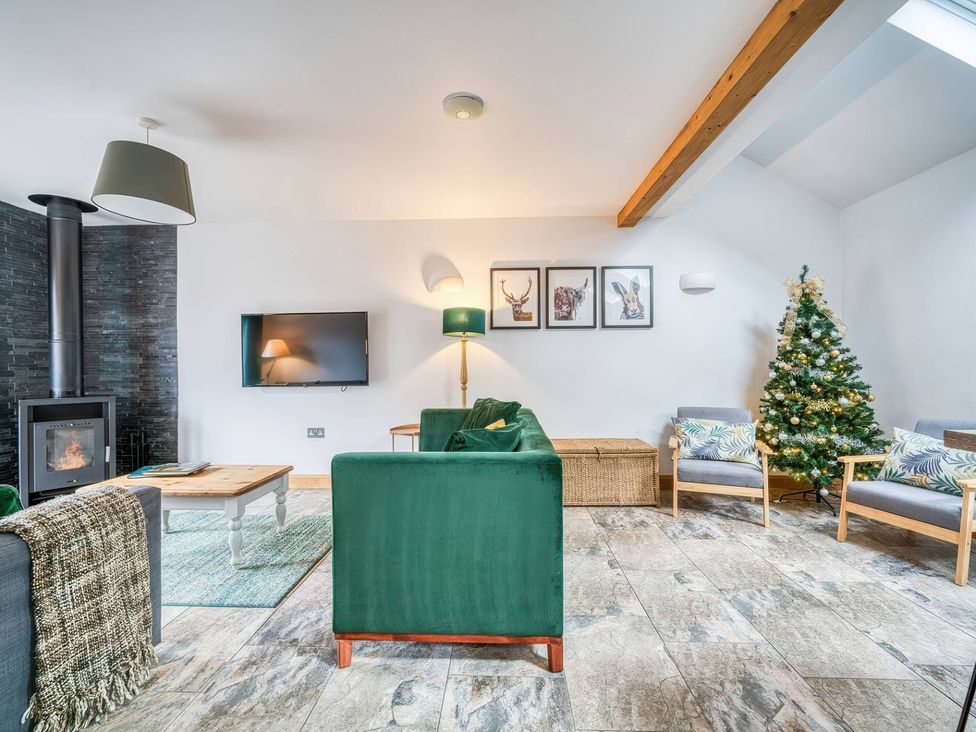 A living room with a sofa, coffee table, and Christmas tree at TBC