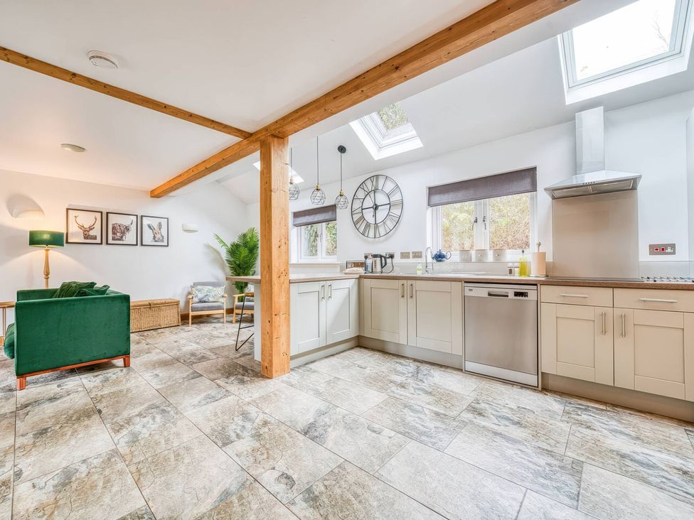 A kitchen with cabinets and a dining table at TBC in 