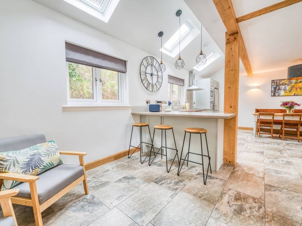 A kitchen with bar stools and a dining table at TBC