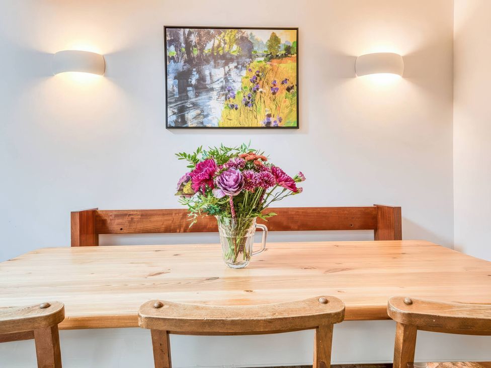 A dining room with a wooden table and chairs at TBC