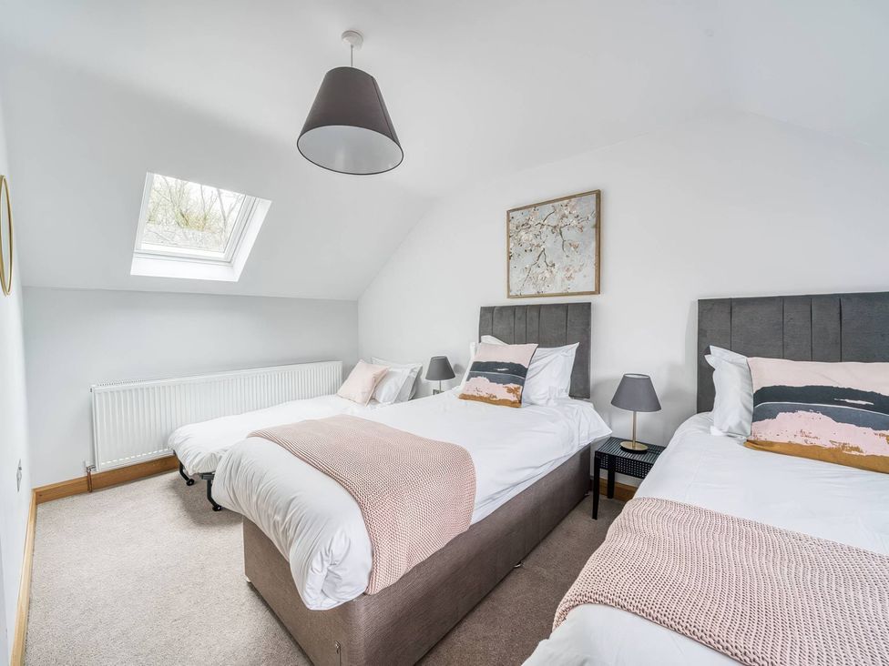 A bedroom with two beds and a skylight at TBC