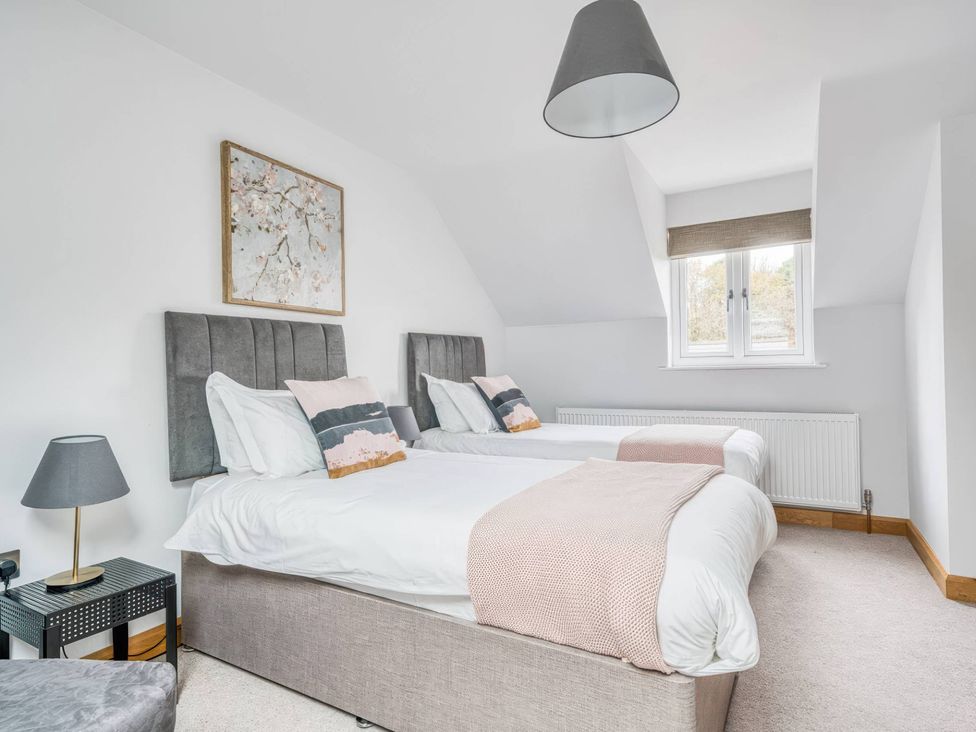 A bedroom with two beds and an artwork at TBC