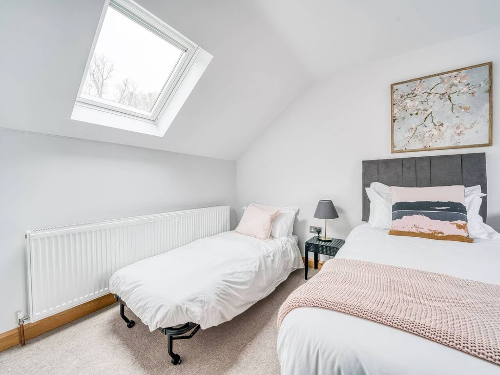 A bedroom with two beds and a skylight at TBC