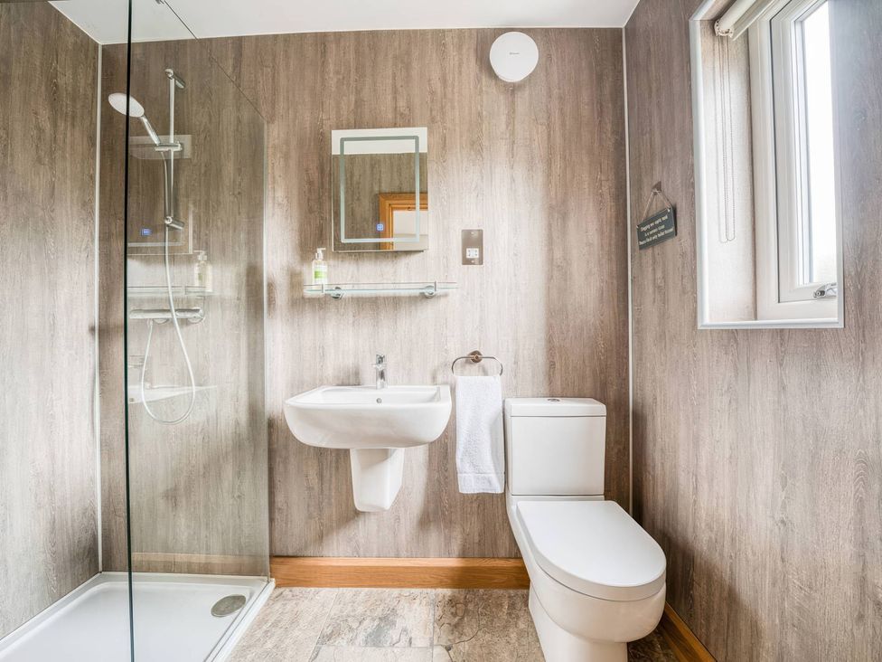 A bathroom with a shower, sink, and toilet at TBC 
