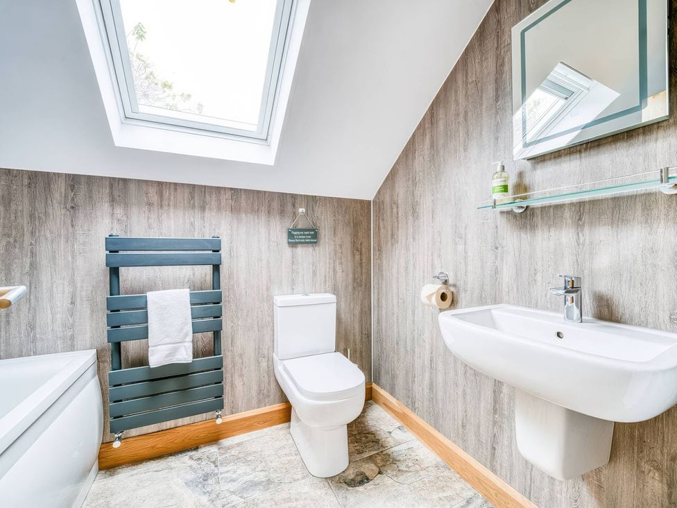 A bathroom with a toilet, sink, and towel rail at TBC