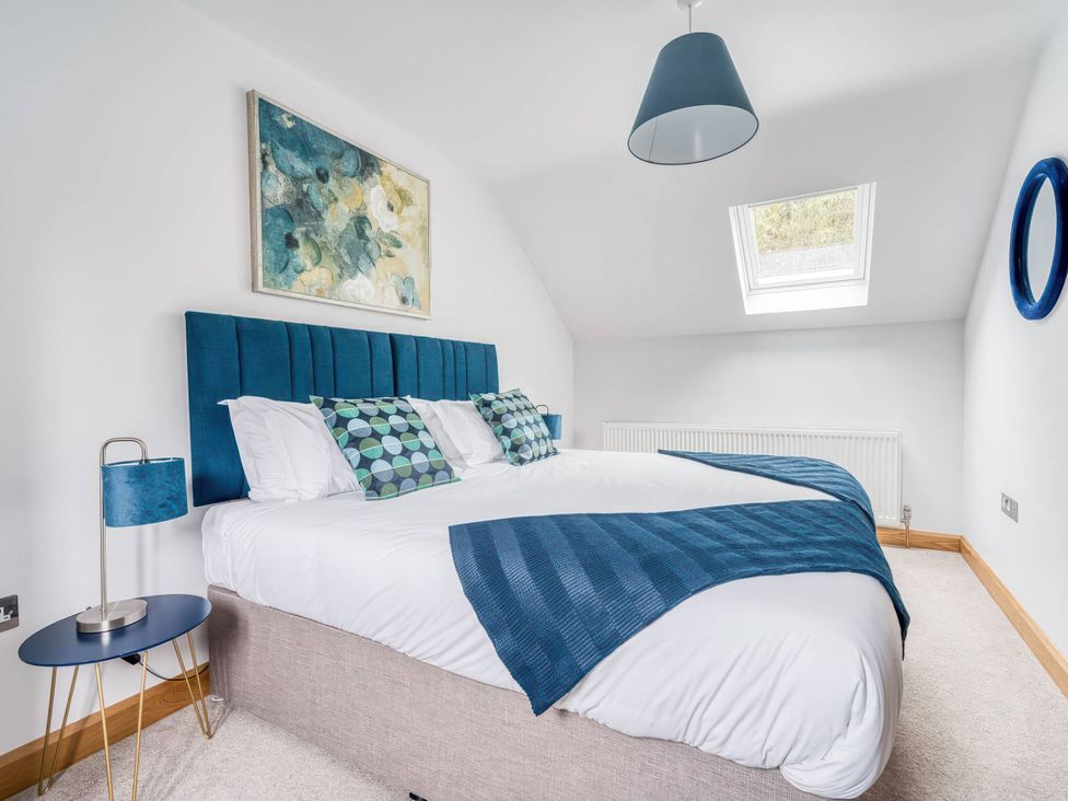 A bedroom with a bed and bedside lamp at TBC