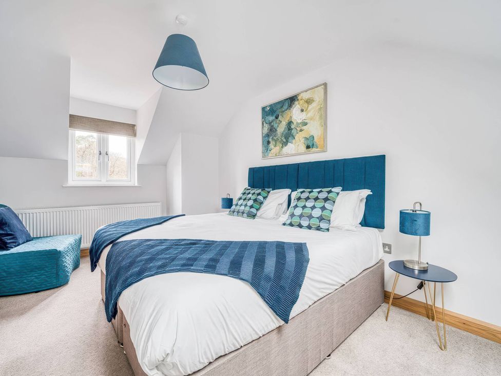 A bedroom with a bed and lamp at TBC
