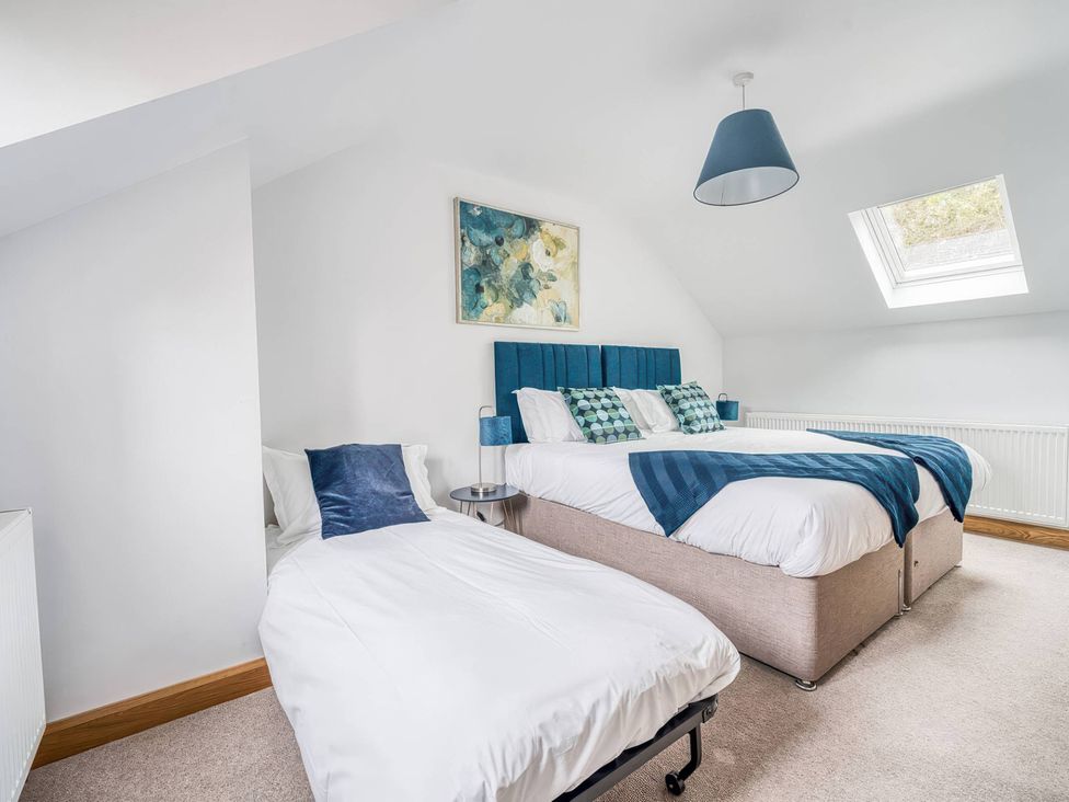 A bedroom with beds and artwork at TBC