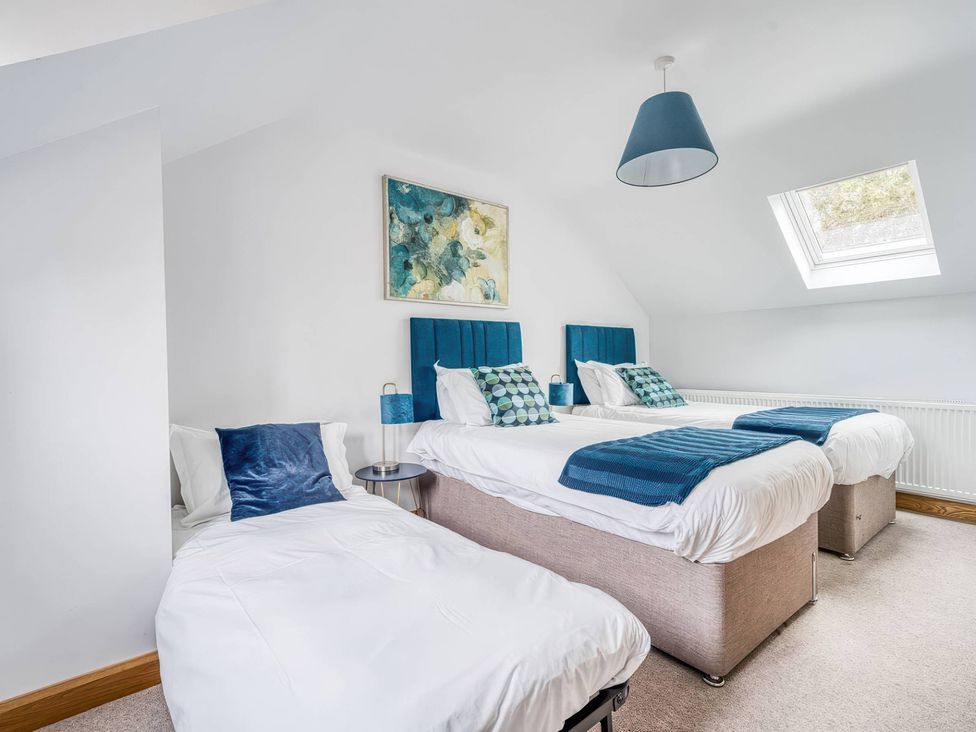 A bedroom with three beds and a skylight at TBC
