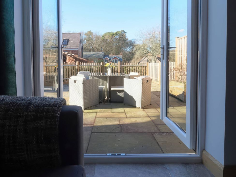 A patio with furniture visible through a glass door at TBC