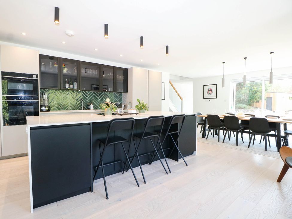 A kitchen with bar stools and dining table at Cree Cottage