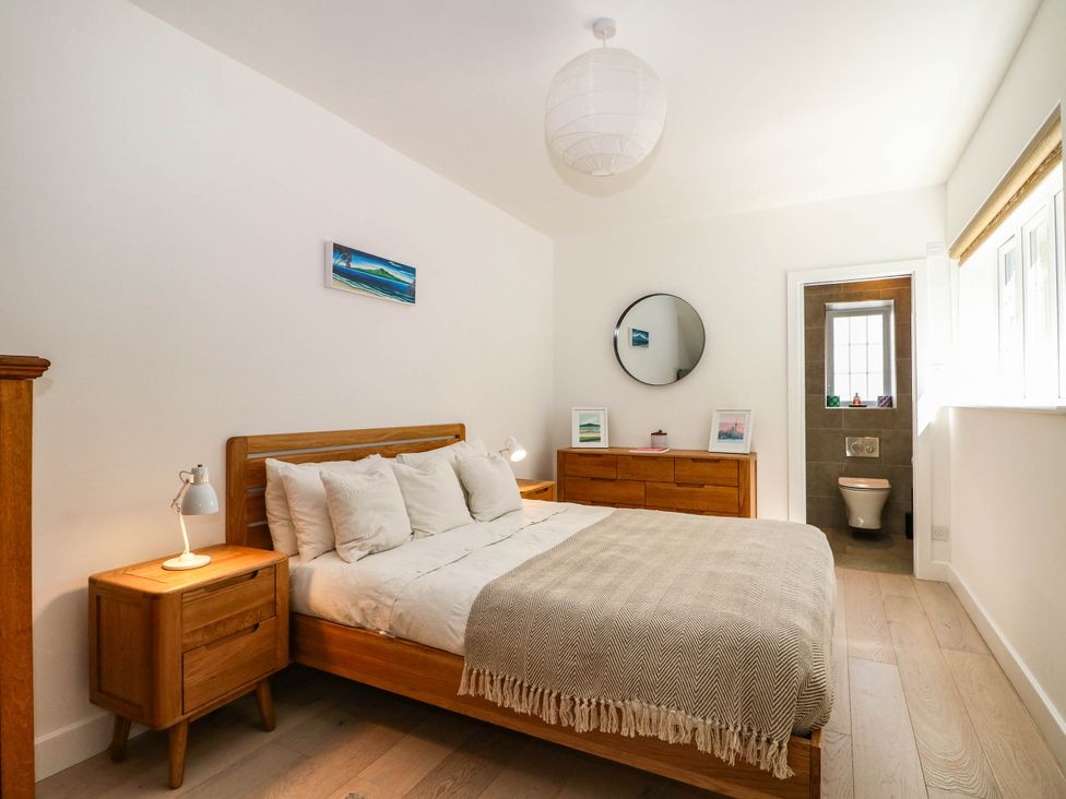 A bedroom with a bed, nightstand and dresser at Cree Cottage