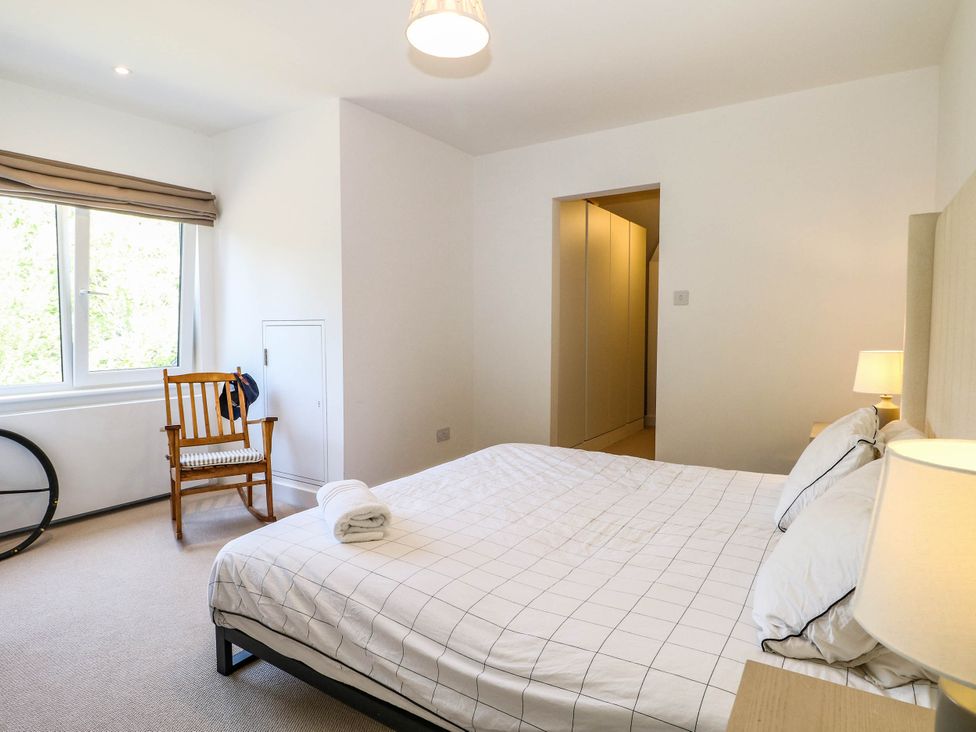 A bedroom with a bed and chair at Cree Cottage