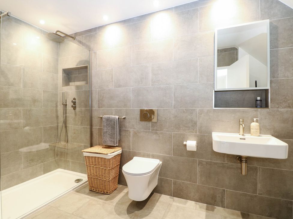 A bathroom with a shower, sink, toilet and towel rack at Cree Cottage
