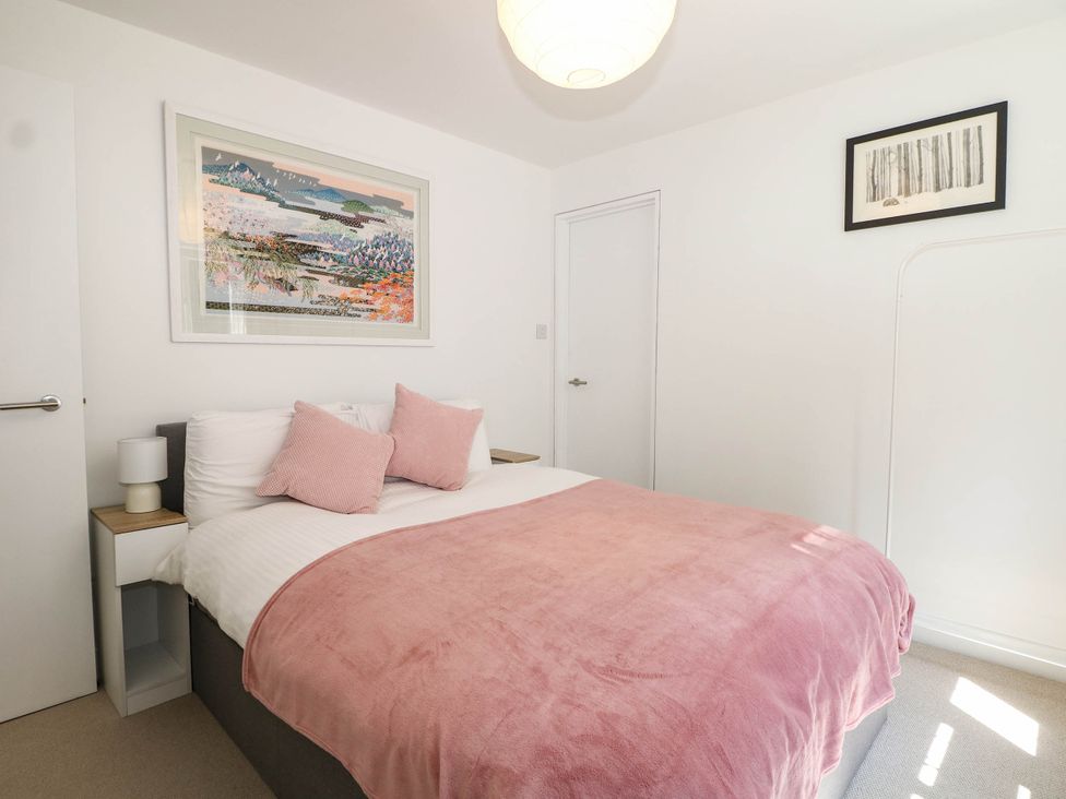 A bedroom with a bed and artwork at Cree Cottage