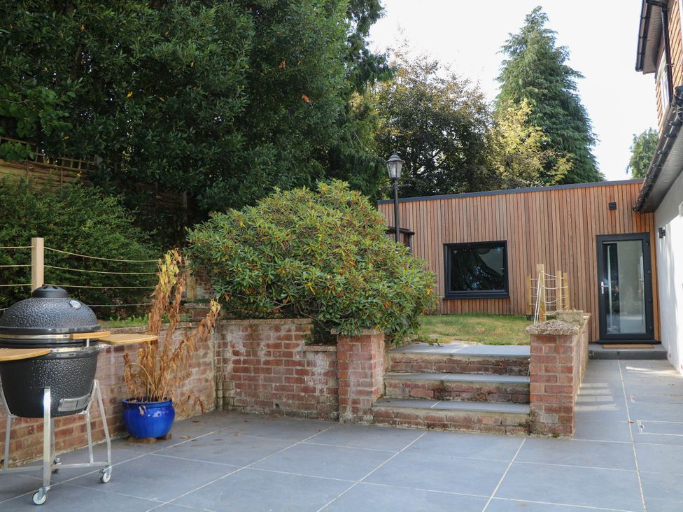 A patio with a grill and steps leading to a house at Cree Cottage