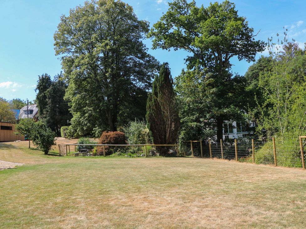 A garden with grass and trees at Cree Cottage