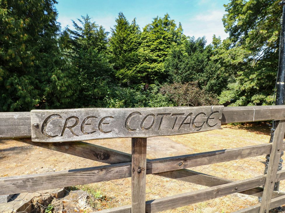 A wooden sign reading Cree Cottage at Cree Cottage