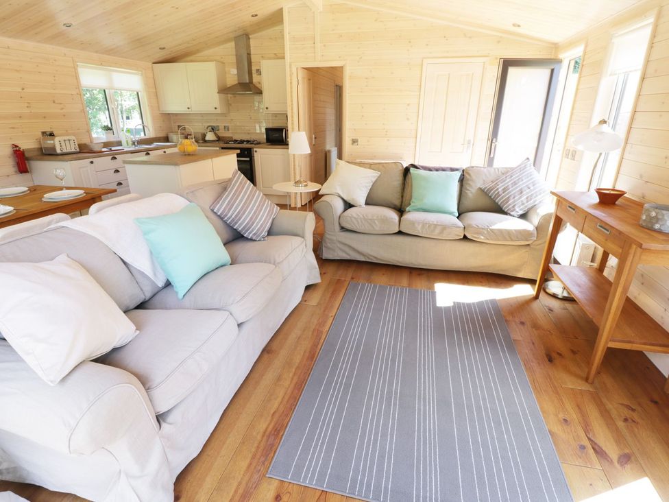 A living room with two sofas and a wooden table at Kingfisher in Ross-on-Wye