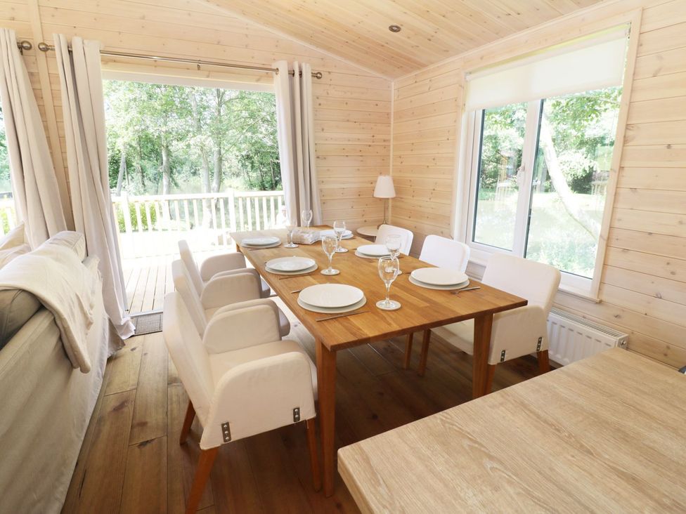 A dining room with a table set for six at Kingfisher in Ross-on-Wye