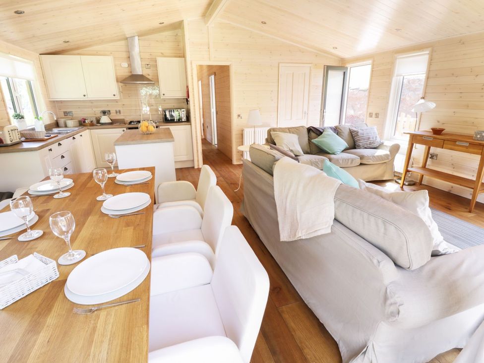 A kitchen and dining area with a table and sofa at Kingfisher in Ross-on-Wye