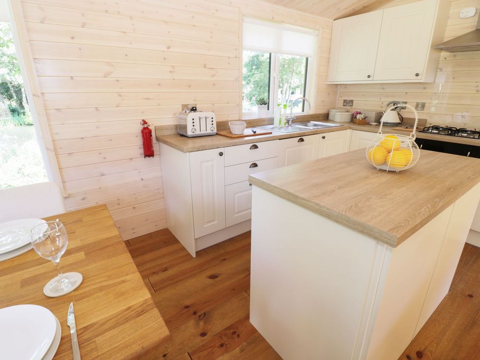 A kitchen with a sink and island at Kingfisher in Ross-on-Wye