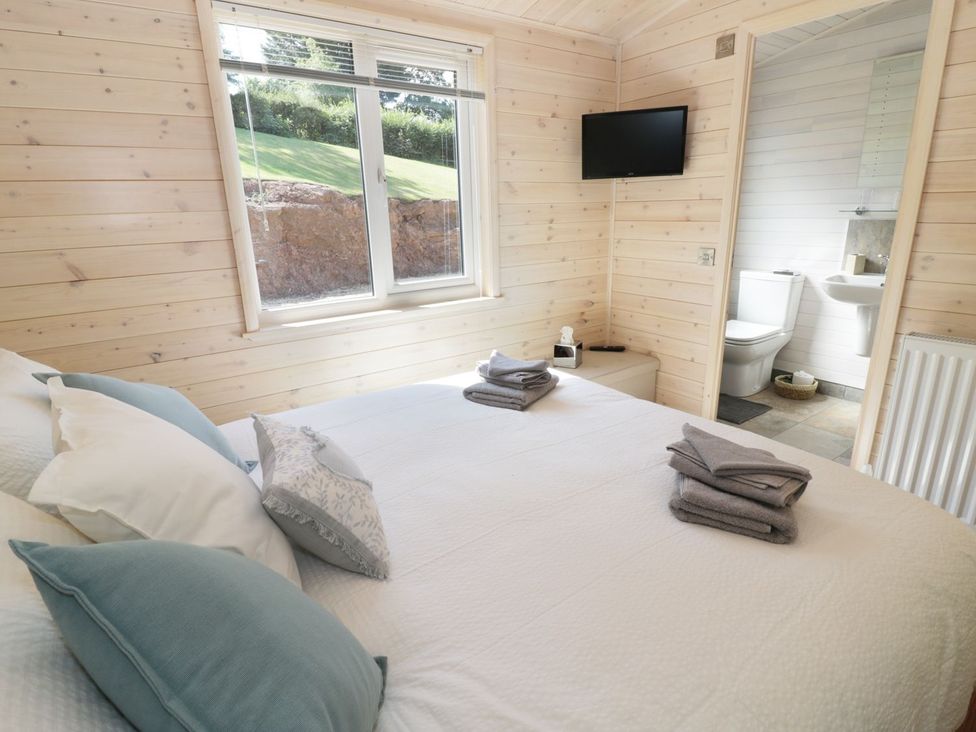 A bedroom with a double bed and ensuite bathroom at Kingfisher in Ross-on-Wye