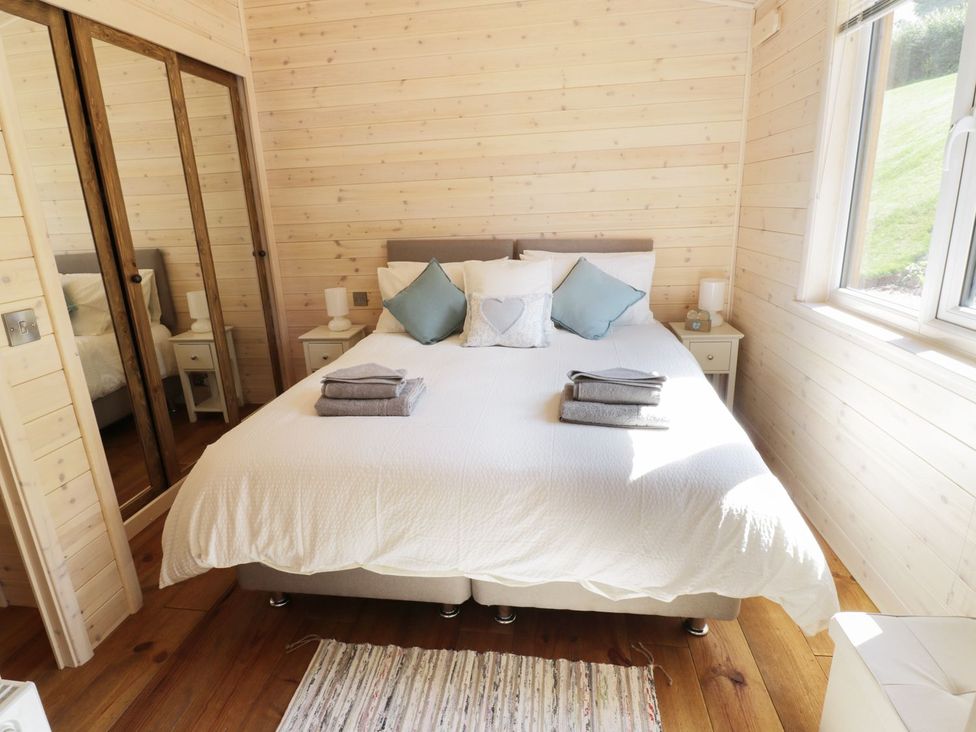 A bedroom with a bed and bedside tables at Kingfisher in Ross-on-Wye