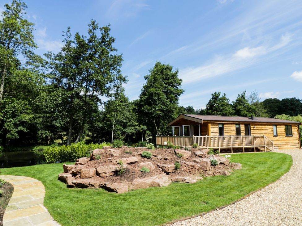A cabin with a deck by a pond at Kingfisher in Ross-on-Wye