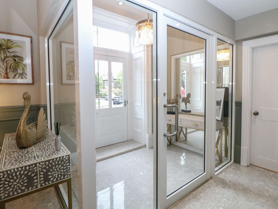 A hallway with a table and door at The Pavillon Suite in Buxton