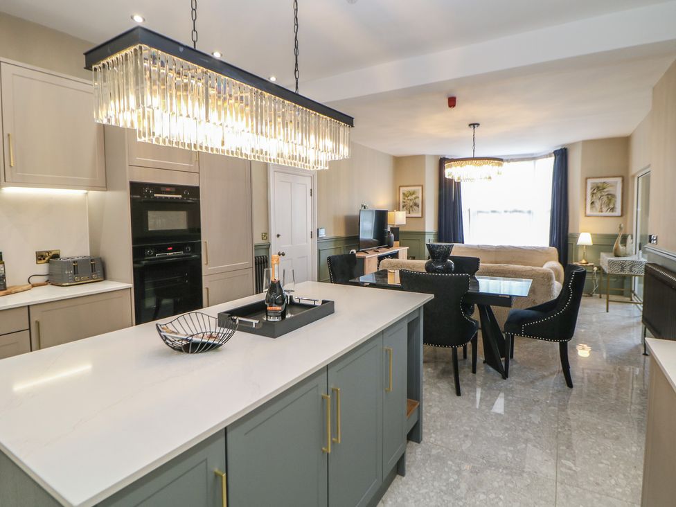 A kitchen and dining area with a table and chairs at The Pavillon Suite in Buxton