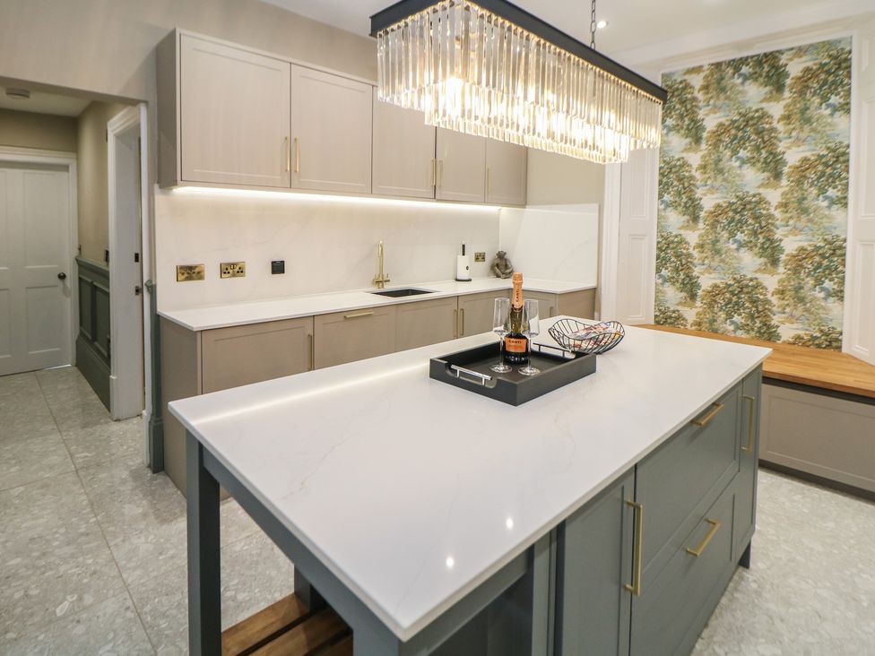 A kitchen with a central island and wall cabinets at The Pavillon Suite in Buxton