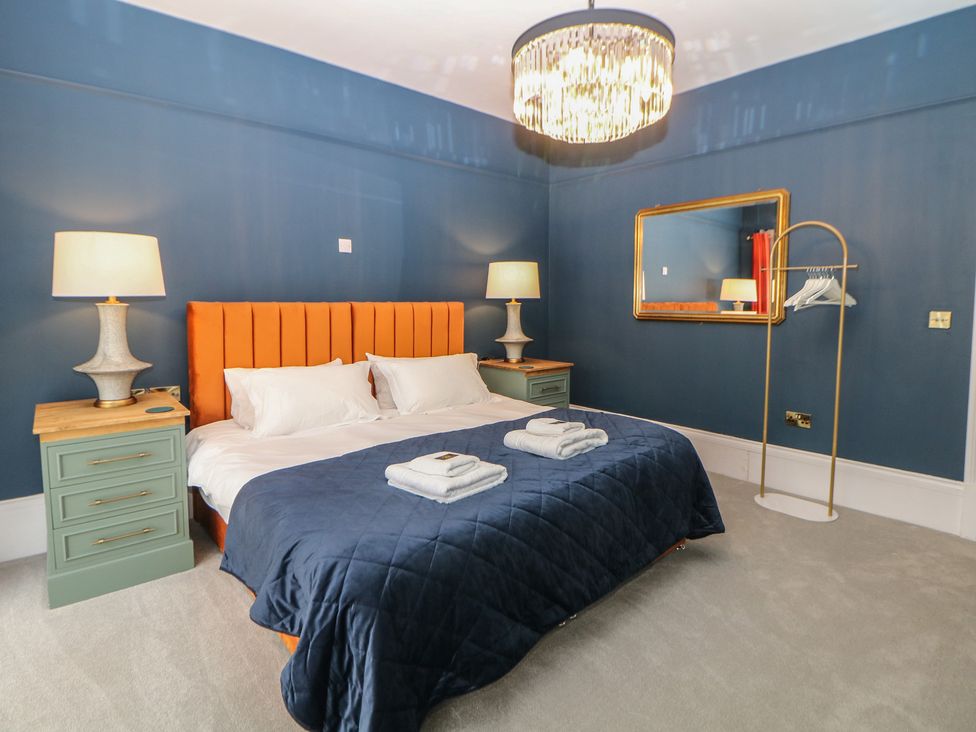 A bedroom with a bed and side tables at The Pavillon Suite in Buxton