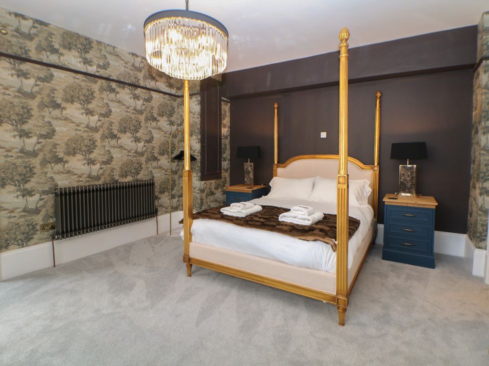 A bedroom with a four-poster bed and side tables at The Pavillon Suite in Buxton