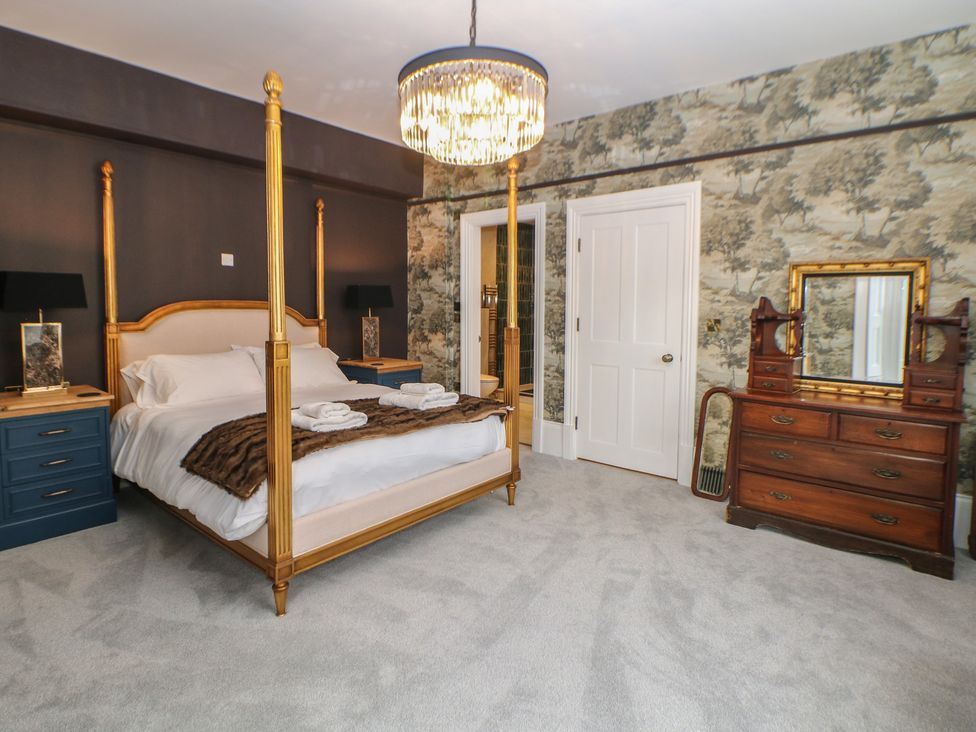 A bedroom with a four-poster bed and dresser at The Pavillon Suite in Buxton