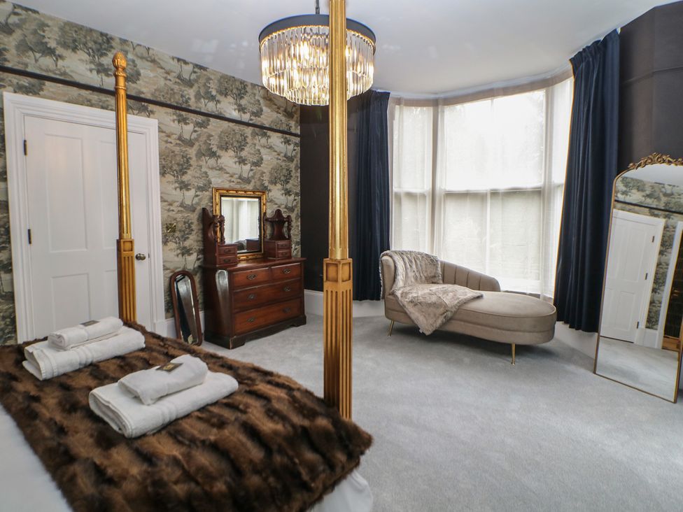 A bedroom with a bed and mirror at The Pavillon Suite in Buxton
