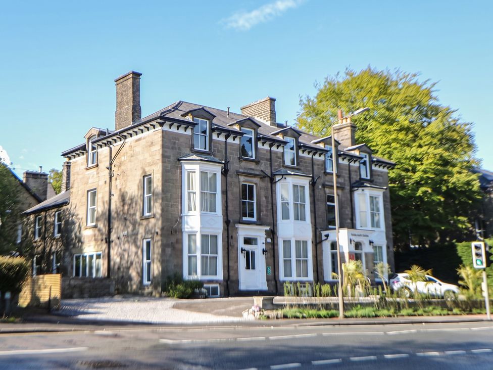 A stone building with multiple windows and doors at The Pavillon Suite in Buxton