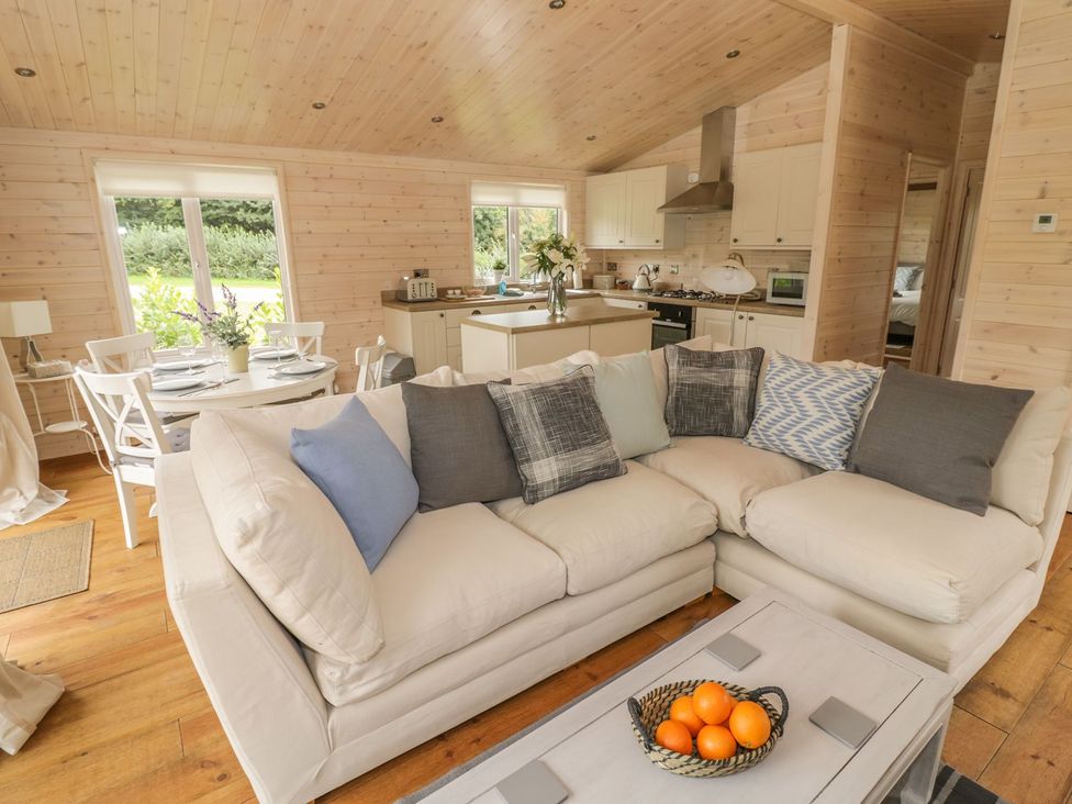 A living room with a sofa, coffee table, and dining area at Mallard in Ross-on-Wye
