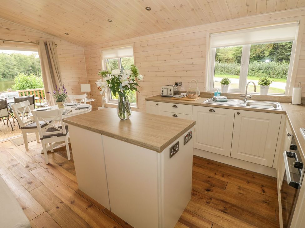 A kitchen with an island and dining area at Mallard in Ross-on-Wye