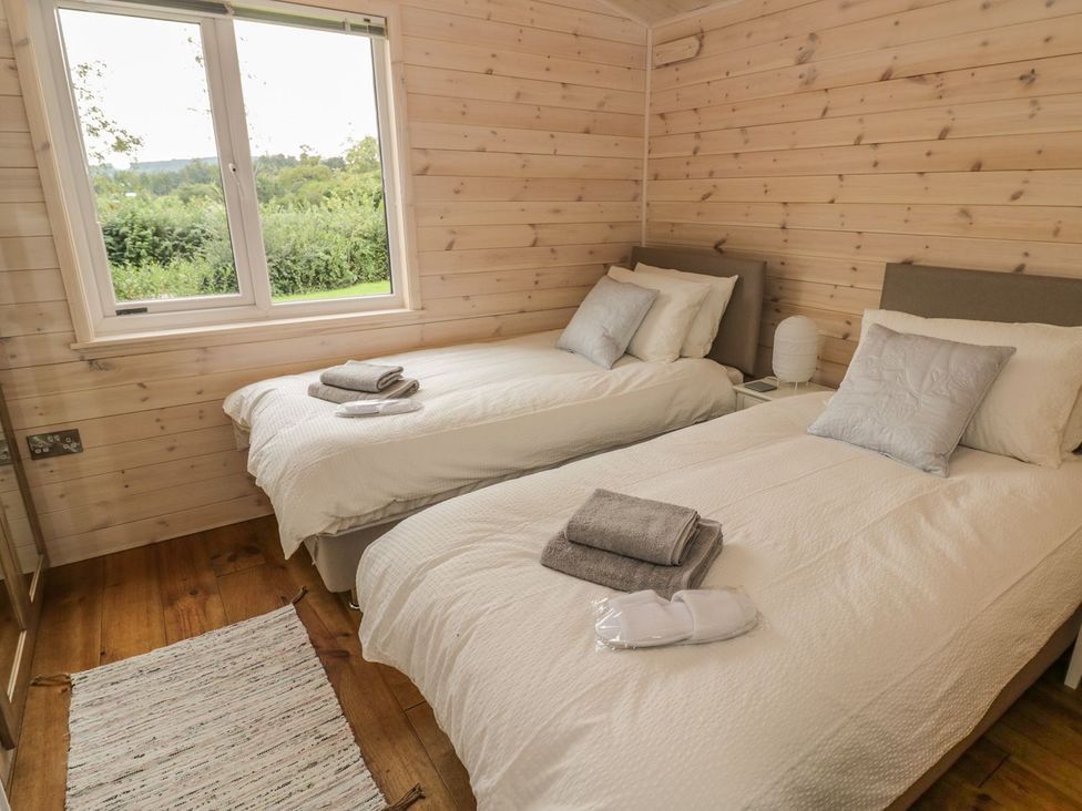 A bedroom with two single beds and a window at Mallard in Ross-on-Wye