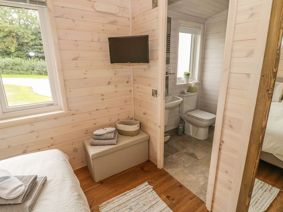 A bedroom with a bathroom visible with a toilet and sink at Mallard in Ross-on-Wye