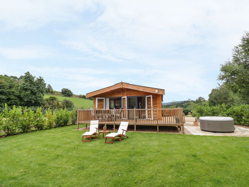 A log cabin with a deck and hot tub in the garden at Mallard in Ross-on-Wye