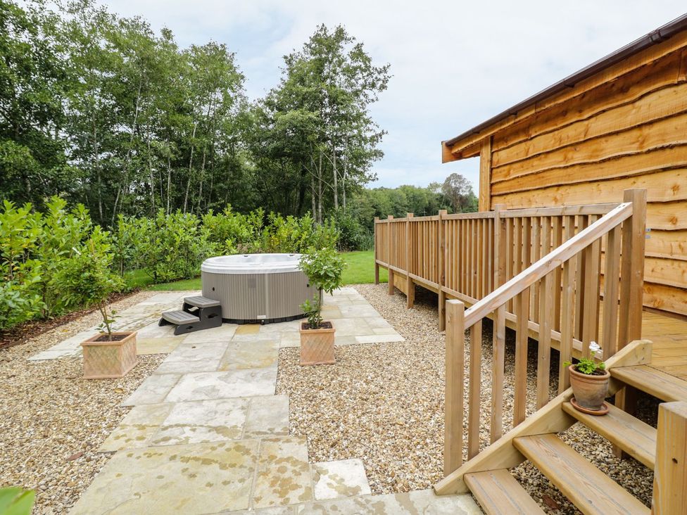 An outdoor area with a hot tub and decking at Mallard in Ross-on-Wye