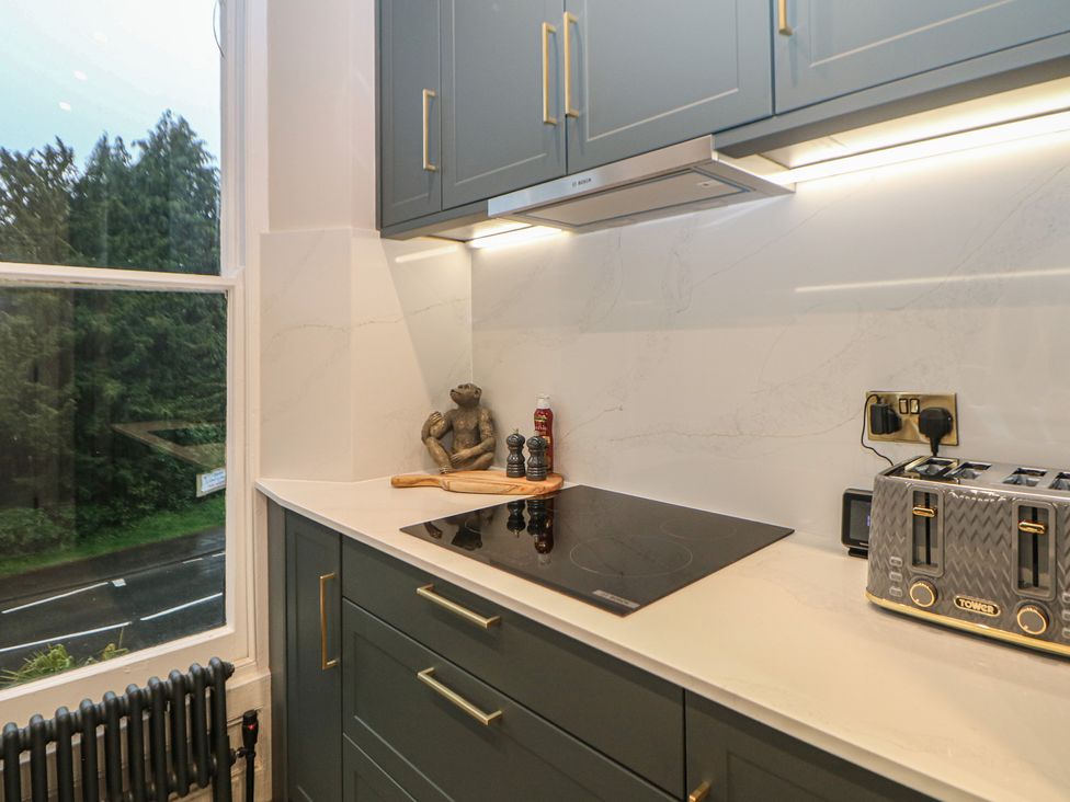 A kitchen featuring an induction cooktop, toaster, and shakers at The Haddon Suite Buxton