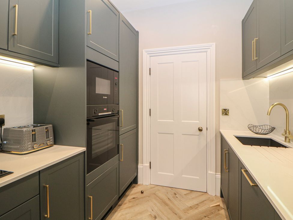 A kitchen featuring a microwave, toaster, and sink at The Haddon Suite in Buxton