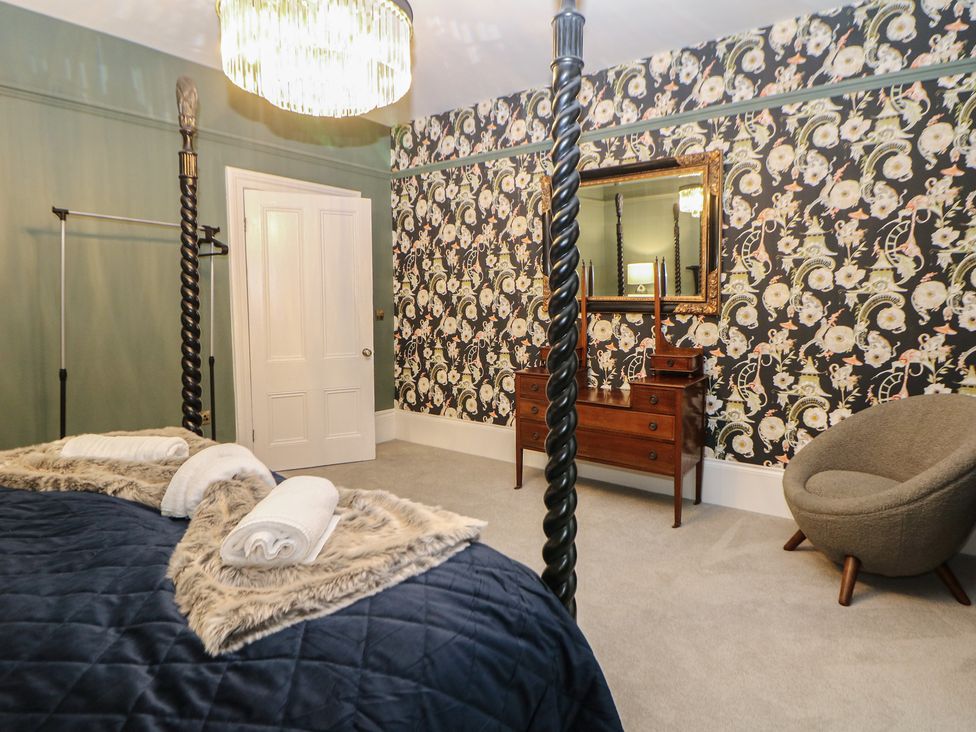 A bedroom with a bed and a dresser at The Haddon Suite in Buxton